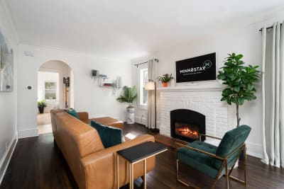 Inviting living room with leather furniture and a white-brick fireplace.