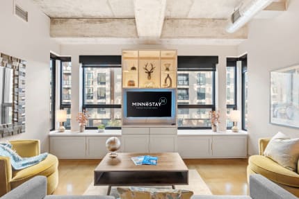 Modern living room with large windows, a TV unit, and decorative elements.