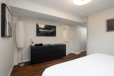 Modern room with a bed, black media cabinet, and flat-screen TV.