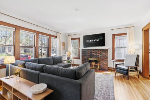 Cozy living room featuring a gray sectional sofa, fireplace, and large windows.