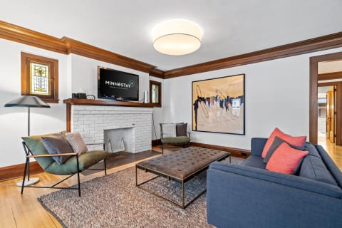 Cozy modern living room with fireplace, TV, and artistic decor.