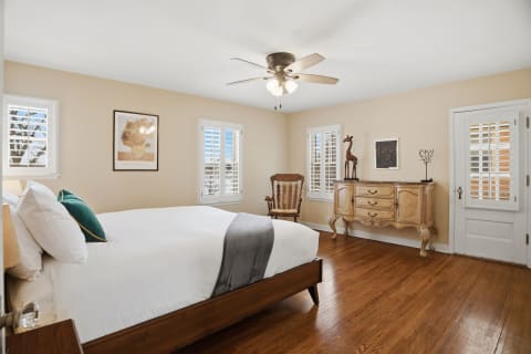Inviting bedroom with hardwood floors, a bed, and vintage furnishings.