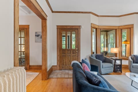 Interior view of a living room featuring a blue sofa, gray armchairs, and wooden accents.