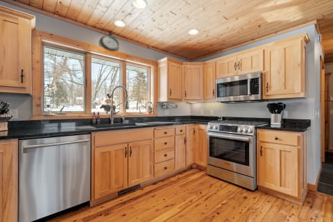 Interior view of a modern kitchen with wooden cabinets and dark granite countertops.