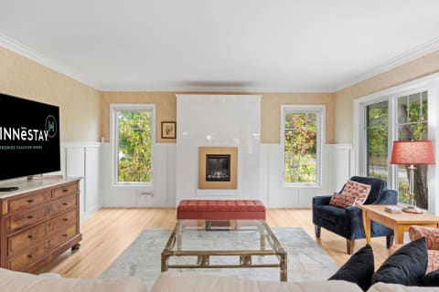 A cozy living room featuring a fireplace, TV, and stylish furnishings.