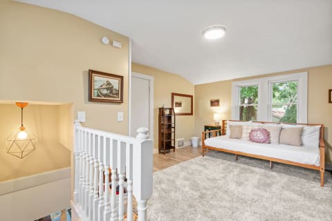 Cozy room with a daybed, decorative pillows, and warm lighting.