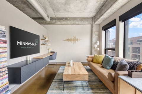 Modern living room with exposed concrete, stylish furnishings, and decorative elements.