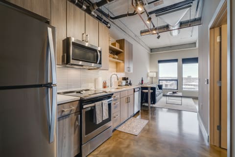 Contemporary apartment kitchen with stainless steel appliances and sleek design.