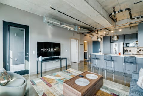 Stylish apartment interior featuring a modern sofa, kitchen island, and contemporary decor.